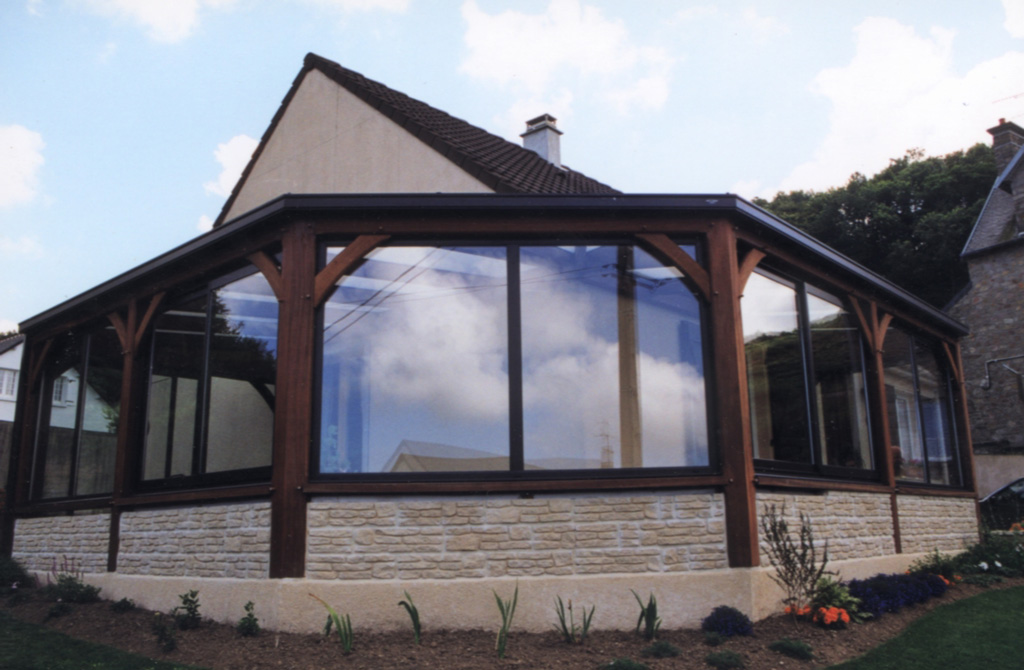 Veranda avec grand pan coupé en bois exotique